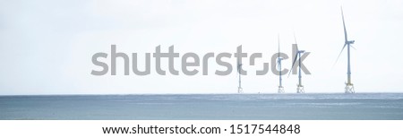 Wind turbines at electric power farm in the North Sea in Aberdeen for renewable energy production and environment conservation panoramic banner