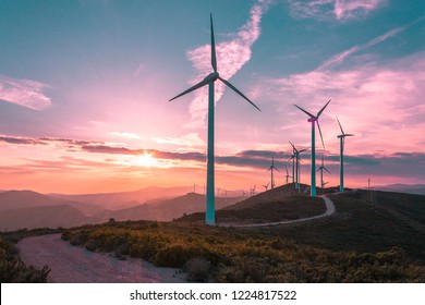 Wind turbines on beautiful sunny summer purple autumn mountain landsape. Curvy road through mountain Eolic park. Green ecological power energy generation. Wind farm eco field