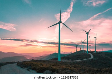 Wind Turbines On Beautiful Sunny Summer Purple Autumn Mountain Landsape. Curvy Road Through Mountain Eolic Park. Green Ecological Power Energy Generation. Wind Farm Eco Field