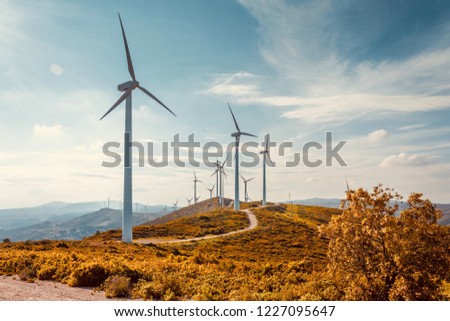 Wind turbines on beautiful sunny summer autumn mountain landsape. Curvy road through mountain Eolic park. Green ecological power energy generation. Wind farm eco field
