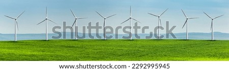 Wind turbines on a green field in a hilly landscape