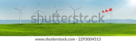 Wind turbines on a green field in a hilly landscape