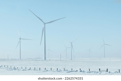 Wind turbines on an open field, wind farm in winter under a blue sky - Shutterstock ID 2262574331