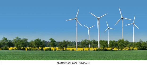 Wind turbines in a rapeseed field behind an alley