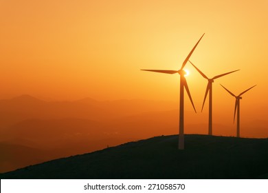 wind turbines silhouette on mountain at the sunset