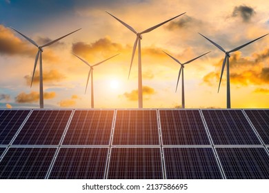 Wind turbines and solar panels at sunset. renewable energy concept.