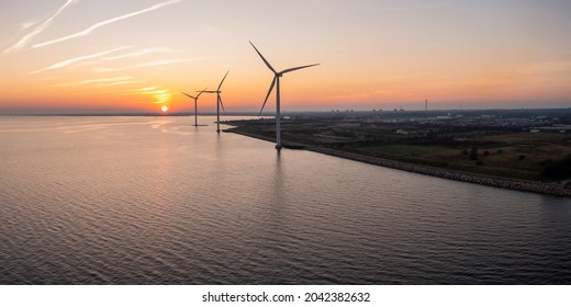 Wind turbines at sunset. Green ecological power energy generation. Wind farm eco field. Offshore and onshore windmill farm green energy at sea. - Shutterstock ID 2042382632
