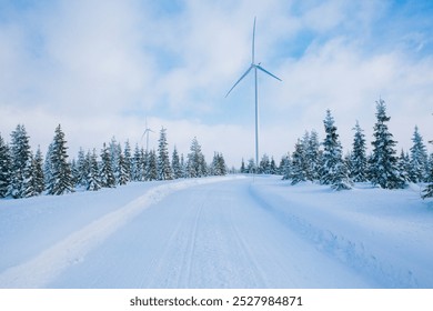 Wind turbines in winter landscape with snow covered trees and snow road in Finland, Europe. Alternative energy in winter. - Powered by Shutterstock