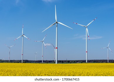 Wind wheels and a flowering canola field seen in Germany