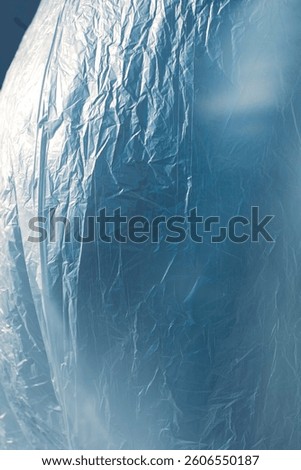 The wind whispers across the delicate surface of the nylon, lifting and folding it into endless waves of motion. It plays like an invisible artist, sculpting creases and curves with each passing gust.