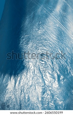 The wind whispers across the delicate surface of the nylon, lifting and folding it into endless waves of motion. It plays like an invisible artist, sculpting creases and curves with each passing gust.