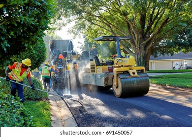 WINDERMERE, FLORIDA, USA - MAY 18, 2017: Asphalt Paving Crew Using Heavy Machinery Repaving A Residential Neighborhood On A Bright Florida Morning.