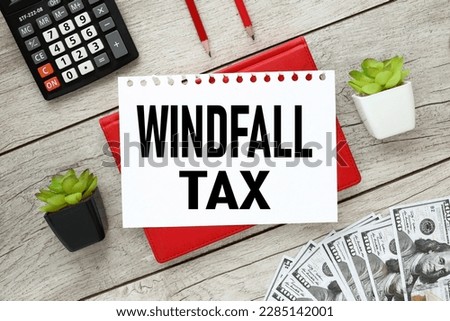 Windfall tax.white sheet of paper with text. on a red notepad near the calculator