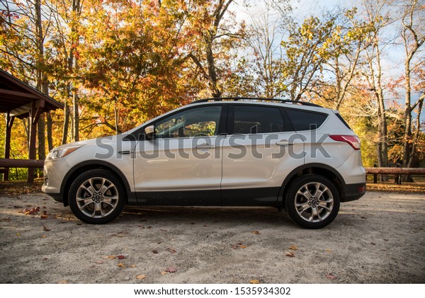 Windham,Maine/United States-10/18/2019 Silver Ford\
Escape parked near lake and fall\
leave