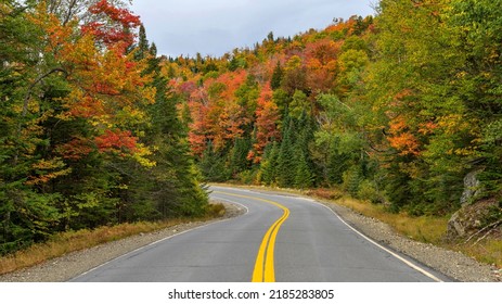 Winding Autumn Road - A wide-angle view of Highway Route 17, part of Rangeley Lake Scenic Byway, winding through a colorful dense mountain forest on a cloudy Autumn morning. West Maine, USA. - Shutterstock ID 2185283805