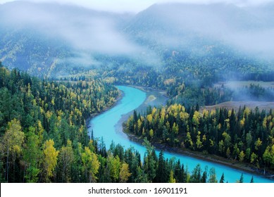 The winding blue river in the colorful forest mountain.
