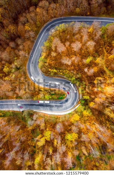Winding curved road with cars and trucks on the\
road. Aerial view.