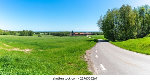 Winding Curvy Country Road In Green Rural Panoramic Landscape In Late Spring.