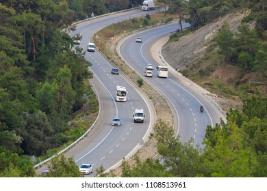 Winding Curvy Rural Road With Light Trail From Headlights Leading Through British Countryside.