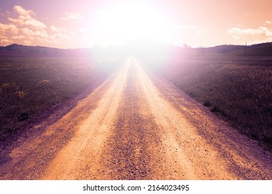 Winding Dirt Road Between Tuscany Spring Fields At Sunset.