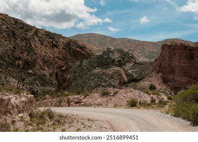 Winding dirt road is passing through a valley with colorful rock formations, showcasing the beauty of nature's artistry - Powered by Shutterstock