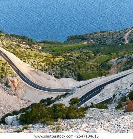 A winding and empty road on the seashore. Island of Brac, Croatia.New, recently built asphalt road.