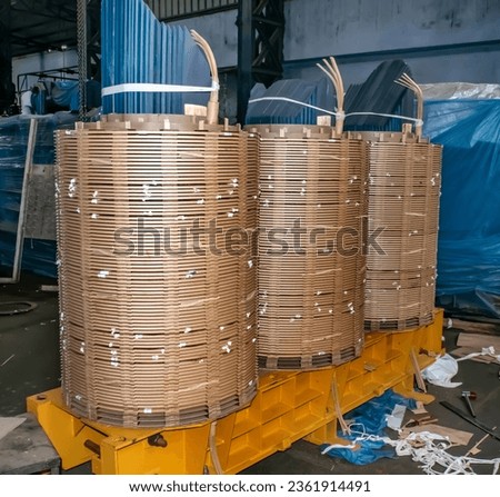 Winding of high voltage power transformer with copper bars - wraps insulation fabric onto transformer core
