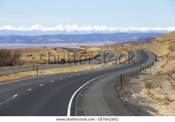 Winding highway in New Mexico with views of the\
Rocky Mountains