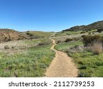 Winding hiking trail across grasslands at Rancho Sierra Vista, Newbury Park, California. Clear blue skies