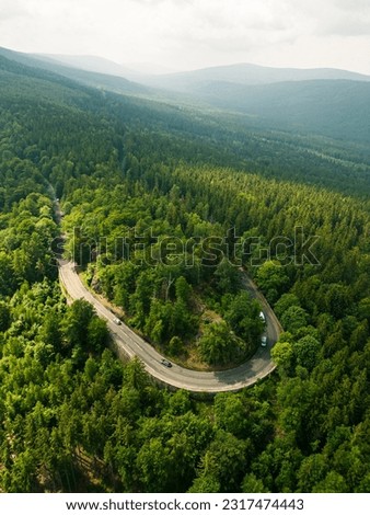 Winding mountain asphalt road. Forest around, mountains in the background. Jizera Mountains. Szklarska Poreba. Lower Silesia.