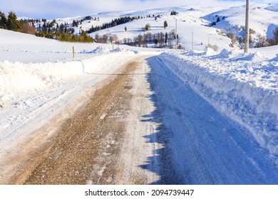 Winding Mountain Road Covered In Fresh Snow. Concept Of Inclement Weather And Dangerous Driving Conditions.