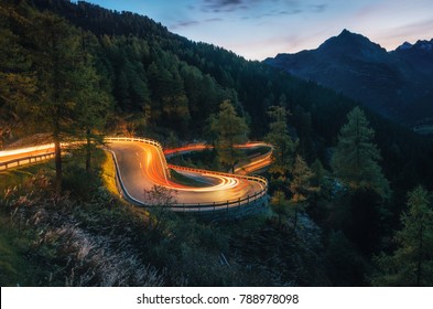 The winding mountain road with light tracks from cars at the evening, Maloja Pass, Switzerland - Powered by Shutterstock