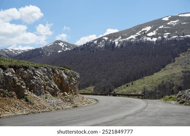 Winding mountain road with snow-capped peaks. - Powered by Shutterstock