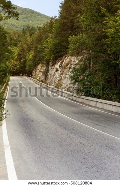 A\
winding mountain road. Two-way road in the mountains. Paved highway\
in a mountainous area near the rocky slopes of\
stone