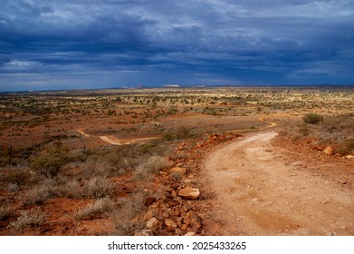 Winding Outback Desert Road And Stormy Sky In Remote Central Australia.