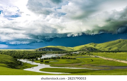 Winding river flows through green grassland, layered storm clouds fill sky, hills and woods stretch across vast wilderness.