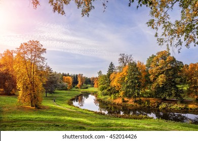 Winding River Slavyanka flows through autumn park and the setting sun