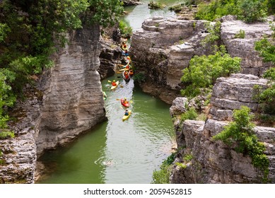 Winding River With Some Kayaks In A Scenic Canyon