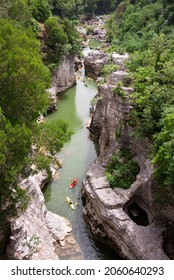 Winding River With Some Kayaks In A Scenic Canyon