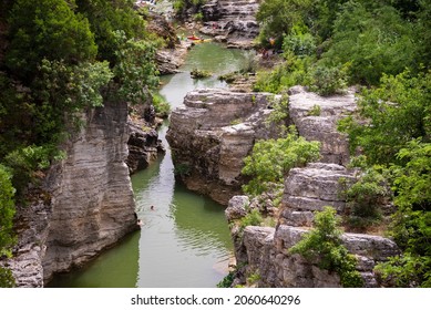 Winding River With Some Kayaks In A Scenic Canyon