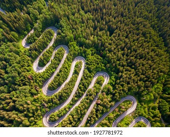 Winding Road Aerial View By Drone. Brasov, Romania. There Are Huge Snow Mountains And Long Winding Road In This Area. This Is A Great Place To Drive And Stop During A Road Trip.