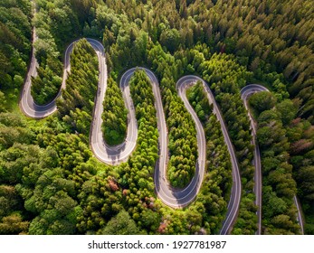 Winding Road Aerial View By Drone. Brasov, Romania. There Are Huge Snow Mountains And Long Winding Road In This Area. This Is A Great Place To Drive And Stop During A Road Trip.