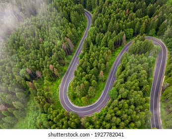 Winding Road Aerial View By Drone. Brasov, Romania. There Are Huge Snow Mountains And Long Winding Road In This Area. This Is A Great Place To Drive And Stop During A Road Trip.