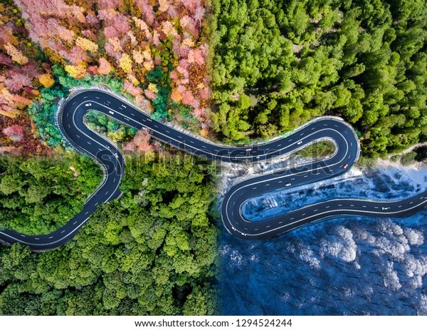 Winding road in all four seasons. Aerial view of a\
curved highway trough the forest. Composite drone roadway weather\
image of a hairpin turn