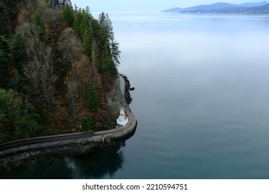 Winding Road Below Cliff Next To Calm Sea