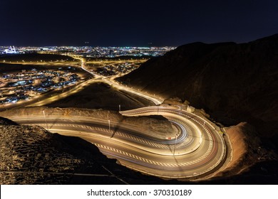 Winding Road And The City Of Muscat At Night. Sultanate Of Oman, Middle East