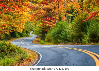 Winding Road Curves Through Scenic Autumn Foliage Trees In New England.