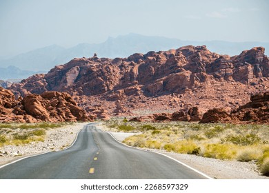 Winding road in the desert with reddish mountains in the bkgrnd - Powered by Shutterstock