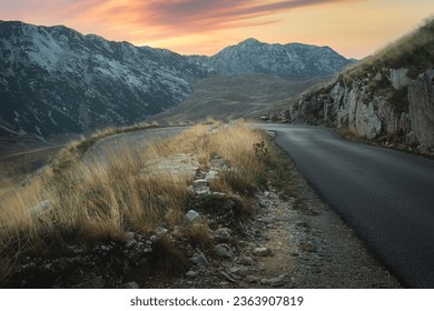 Winding Road To The Durmitor. 
A winding road leads to the Durmitor Mountain Range at sunset in Durmitor  National Park, Montenegro