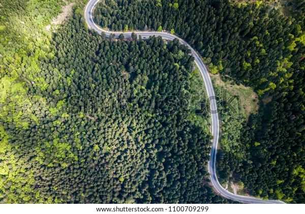 Winding road from high mountain pass, in\
summer time. Aerial view by drone .\
Romania	\
